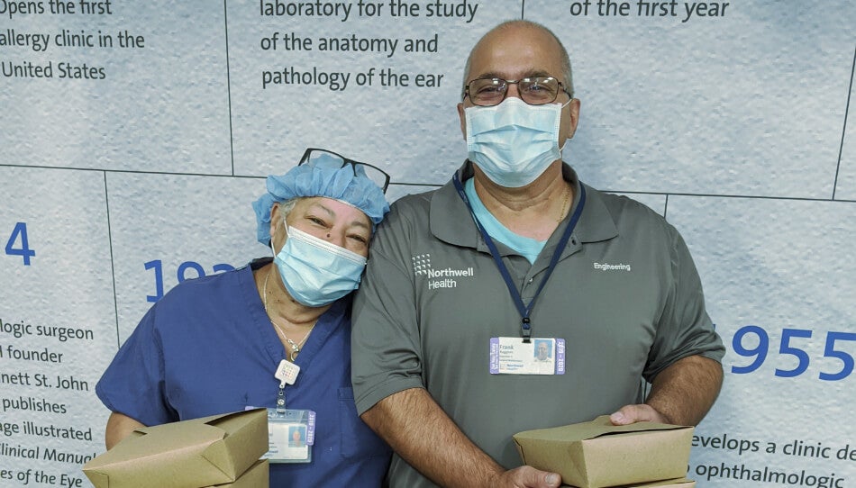 Healthcare workers from Northwell Health holding food boxes, supported by FOOD1st in response to the COVID-19 pandemic.