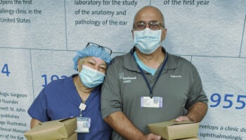 Healthcare workers from Northwell Health holding food boxes, supported by FOOD1st in response to the COVID-19 pandemic.