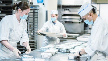 Kitchen workers preparing meals as part of FOOD1st's effort to expand food access in New York City.