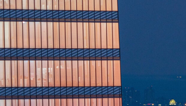 Close-up of a building's exterior with floor-to-ceiling windows, designed to maximize daylighting for interior spaces.