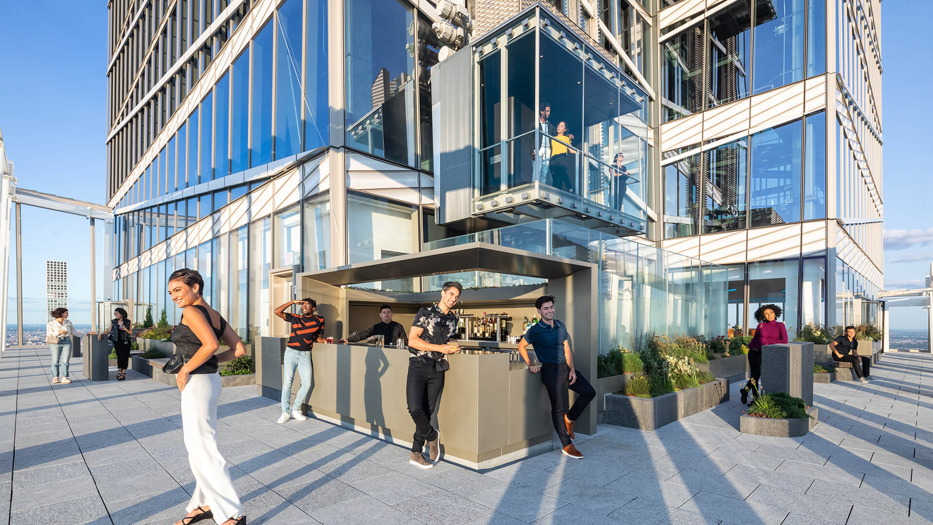 Guests admiring the view of NYC from the SUMMIT One Vanderbilt rooftop bar.
