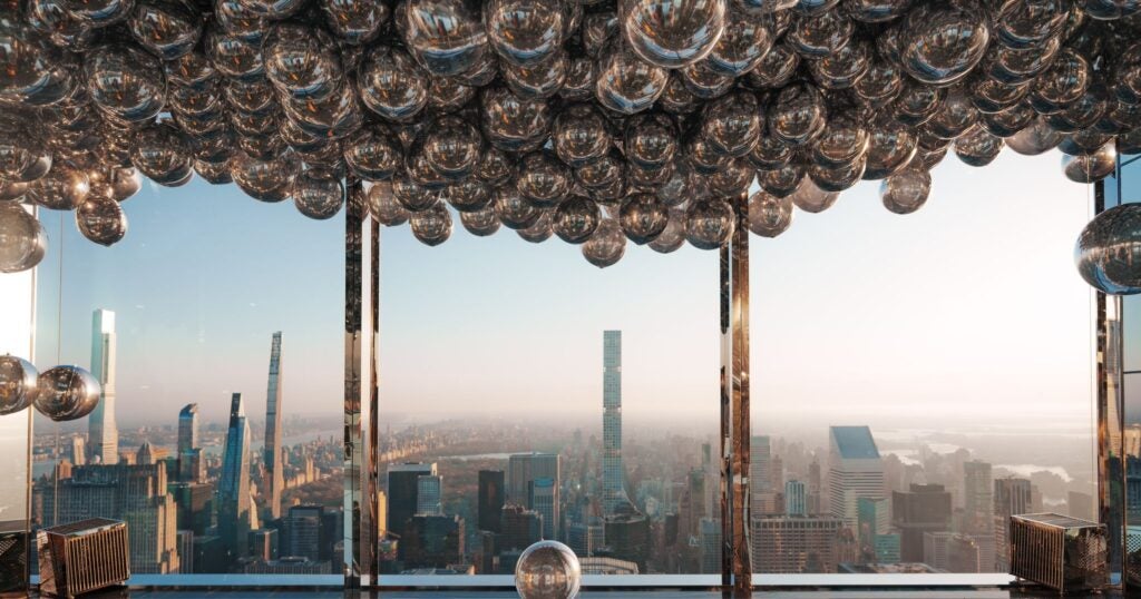 Silver balloons hanging from the ceiling at SUMMIT One Vanderbilt, with panoramic views of New York City.